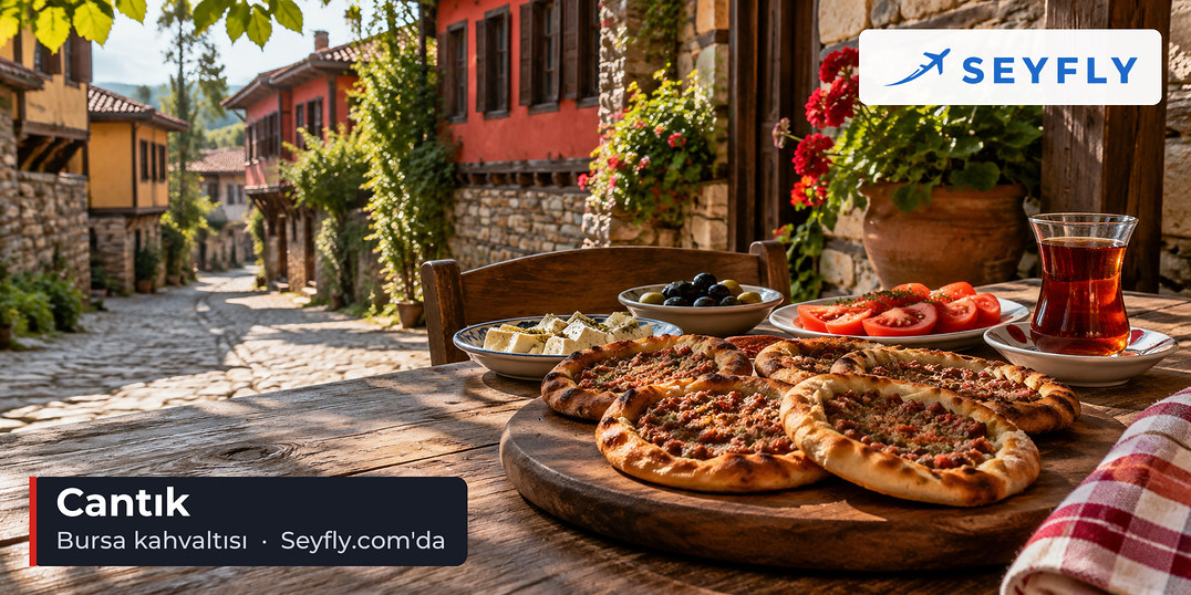 Kahvaltı masasında kıymalı açık pide cantık, domates, zeytin ve çay